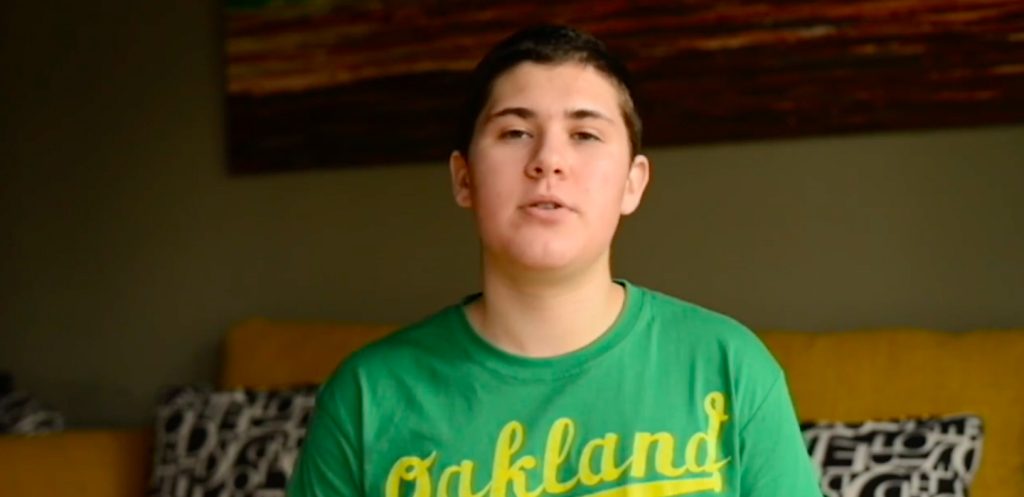 A teenager sitting in a sunlit living room